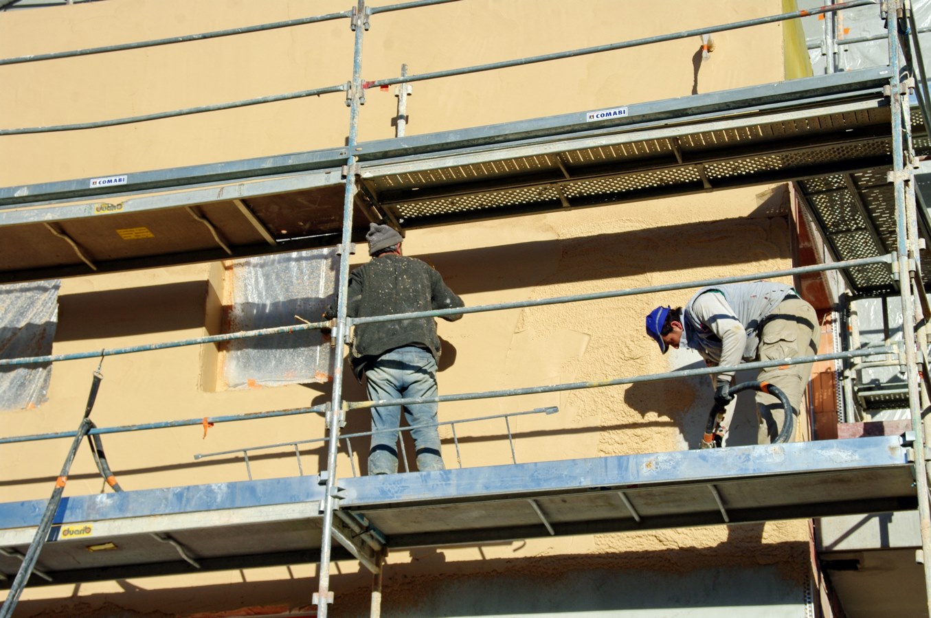 ouvrier qui pose l'enduit de facade